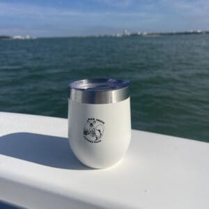 A cup that is sitting on the side of a boat.